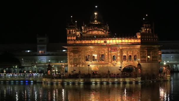 AMRITSAR, INDIA - sikh e indiani che visitano il Tempio d'Oro di Amritsar di notte. I pellegrini sikh viaggiano da tutta l'India per pregare in questo luogo sacro . — Video Stock