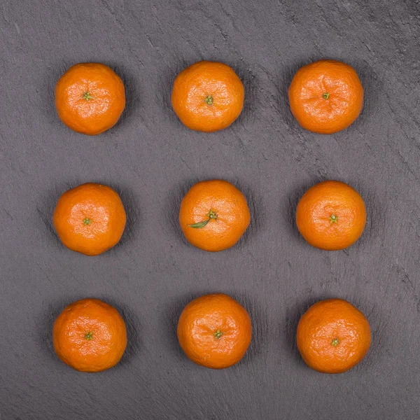 Naranja fresco, fruta de mandarina, patrón de mandarina, vista superior sobre un fondo de pizarra negro, primer plano — Foto de Stock