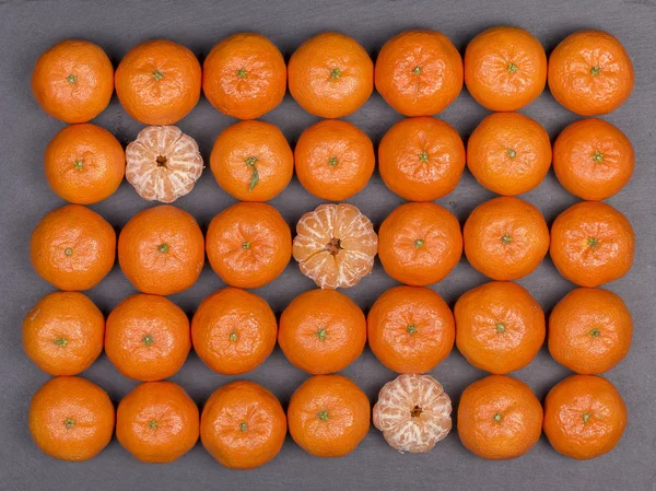 Naranja fresco, fruta de mandarina, patrón de mandarina, vista superior sobre un fondo de pizarra negro, primer plano — Foto de Stock