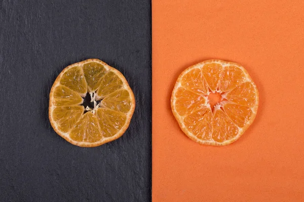 マンダリンにあるオレンジのナプキンと黒いスレートのスライス。健康、オーガニック、ビーガン フード、ビタミンの概念。平面図です。新鮮なオレンジ、タンジェリンの背景 — ストック写真