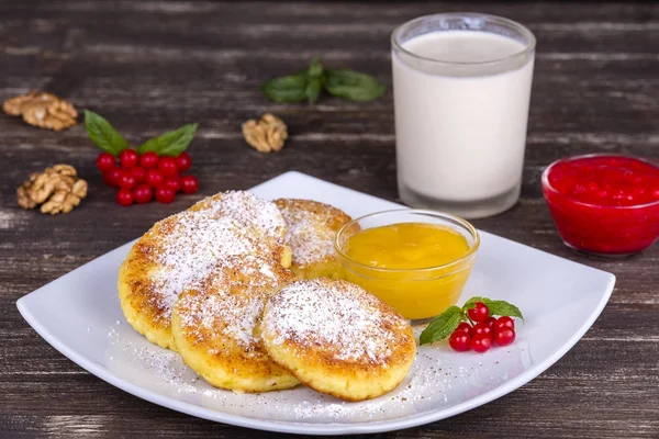 Cottage cheese pancakes, homemade syrniki with honey in white plate. — Stock Photo, Image