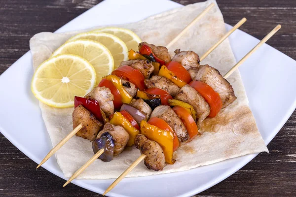 Grilled meat and vegetables on skewer in the plate — Stock Photo, Image