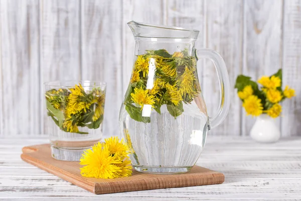 Pissenlit fleur jaune et feuilles vertes thé boisson végétarienne mortier vitamines santé fond en bois — Photo