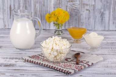 Süzme peynir, ekşi krema, süt ve bal masanın üzerinde. Yakın çekim