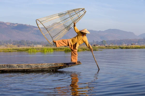 Pescador birmanês em barco de bambu captura de peixe de forma tradicional com rede artesanal. Lago Inle, Mianmar, Birmânia — Fotografia de Stock