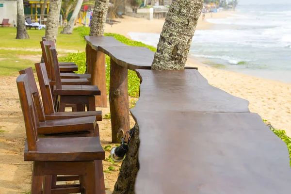 Houten stoelen en tafel in het lege café naast de zee op het tropische strand, Sri Lanka — Stockfoto