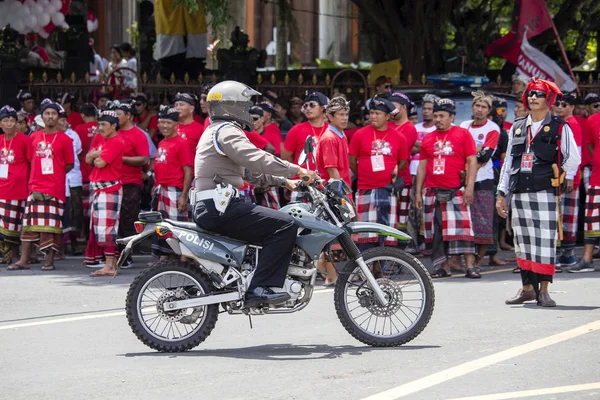 Policeman on motorcycle at street in pre-election rally, the Indonesian Democratic Party of Struggle in Bali, Indonesia Stock Picture