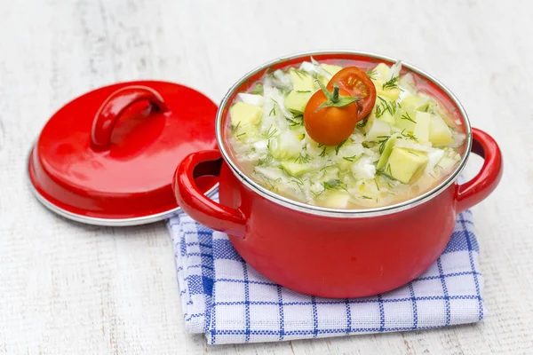 La cacerola roja con okroshka - la sopa tradicional veraniega en Ucrania, Bielorrusia y Rusia. De cerca. —  Fotos de Stock