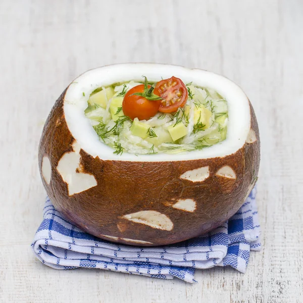 Kokosnussschüssel mit Okroshka - traditionelle Sommersuppe in der Ukraine, Weißrussland und Russland. Nahaufnahme — Stockfoto