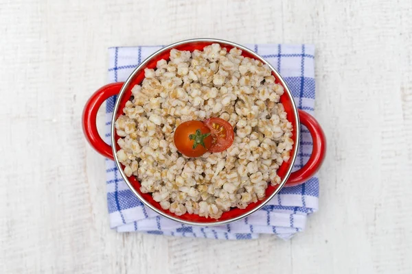 Red pan with wheat porridge - traditional meal in Ukraine, Belarus and Russia — Stock Photo, Image