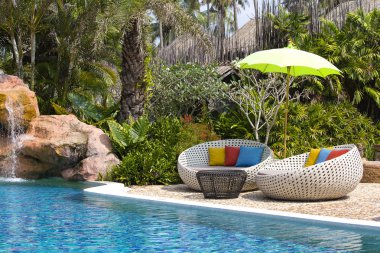 Yüzme Havuzu ve rattan daybeds bir tropik Bahçe, Tayland
