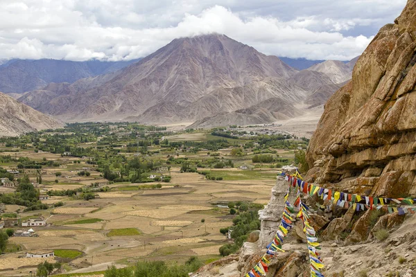 Montanhas do Himalaia e coloridas bandeiras de oração budistas na estupa perto do mosteiro budista em Ladakh, Índia — Fotografia de Stock