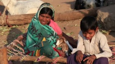 Mandu, Hindistan - 04 Şubat 2017: Tanımlanamayan bir Hint aile goatling ile sokakta oturuyor. Yoksulluk Hindistan önemli bir konudur