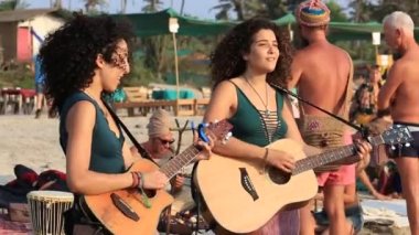 Arambol, Goa, Hindistan - 15 Şubat 2017: Tanımlanamayan sokak müzisyenleri gitar ve denize yakın dans kadın ve erkek oynamak. Goa devlet Arambol beach.