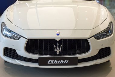 Beyaz Maserati Ghibli kapatın ön yan görünümü marka logosu trident ekran showroom satıcısından Siam Paragon mall Bangkok, Tayland