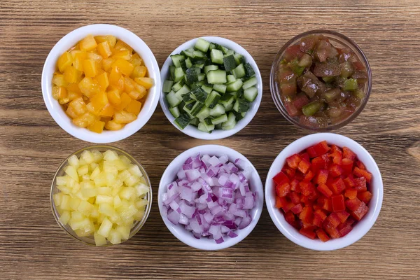 Assortment of colorful vegetables sliced, close up. Fresh peppers, tomatoes, cucumber and onion in bowls. Top view. — Stock Photo, Image