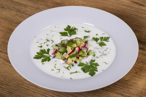 Okroshka. Zuppa di verdure fredde estive con cetriolo, ravanello, uova e aneto su un tavolo di legno. Un piatto tradizionale della cucina russa o ucraina . — Foto Stock