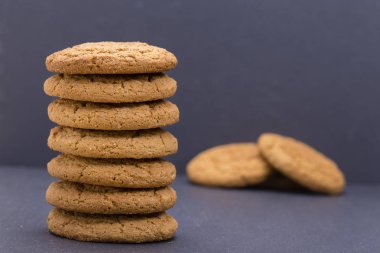 Bir yığın yedi ev yapımı kurabiye - yulaf kurabiye siyah arduvaz arka plan üzerinde