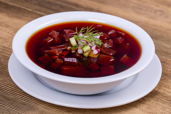 Cold beetroot soup. Summer light cold vegetable soup with beetroot on a wooden table. A traditional dish of russian or ukrainian cuisine
