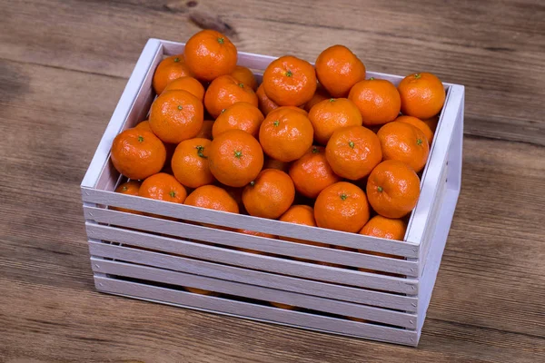 Frische Orangen, Mandarinen, Mandarinenmuster Hintergrund in einer Holzkiste. Konzept gesunder, biologischer und veganer Ernährung — Stockfoto