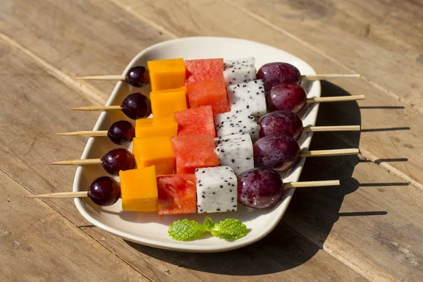 Fresh tropical fruit on skewers in white plate - healthy breakfast, weight loss concept. Thailand
