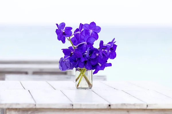Close up beautiful bouquet of orchids flower on wooden table near sea. Thailand — Stock Photo, Image