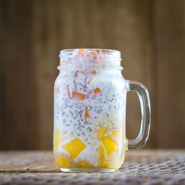 Sağlıklı gıda, chia tohum puding mango, yeşil buğday, papaya, yulaf gevreği, Hindistan cevizi sütü ve müsli, vitamini ile cam bardağa Servis Kahvaltı. Sabah Tayland