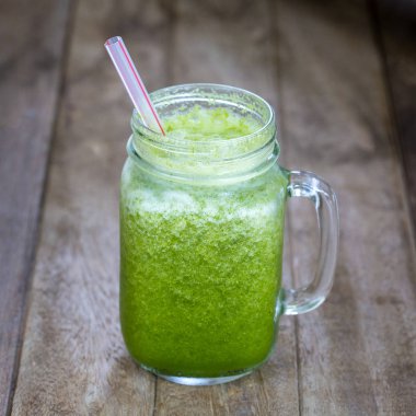 Avokado, muz, dereotu, brokoli ve bal cam kupa ahşap masa üzerinde gelen taze organik smoothies. Yakın çekim