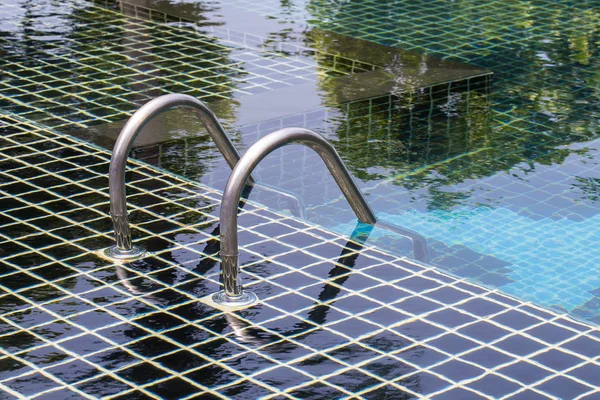 Detail of swimming pool tiles with stairs down water and metal handle — Stock Photo, Image