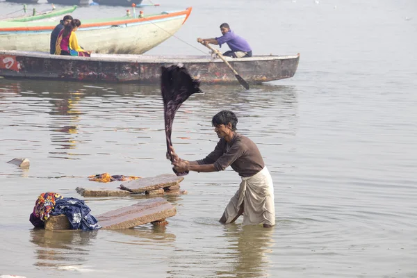 Homens indianos lavam roupas na água benta do rio Ganges na manhã fria de inverno nebulosa. Varanasi. Uttar Pradesh, Índia — Fotografia de Stock