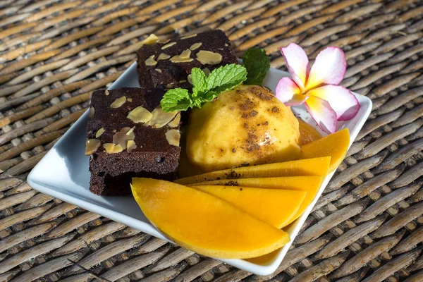 Sorbete de helado de mango orgánico casero fresco con hojas de menta y brownie de chocolate, de cerca. Tailandia — Foto de Stock