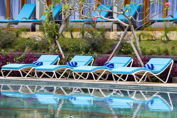 Chaises longues dans jardin tropical près de la piscine sur la plage à Bali, Indonésie — Photo