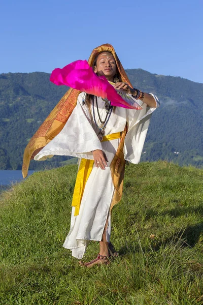 Guy in women clothes dancing with a fan at sunrise in Pokhara, Nepal — Stock Photo, Image