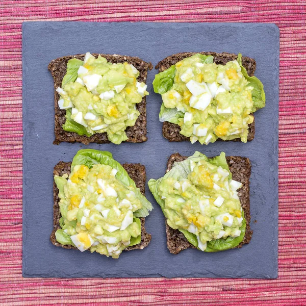 Sandwich con aguacate y huevo escalfado - concepto de desayuno saludable —  Fotos de Stock