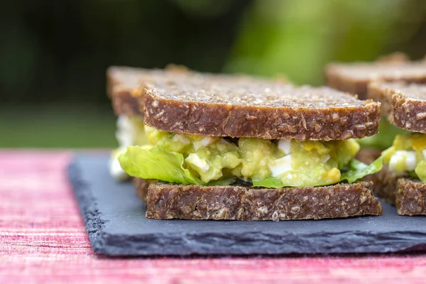 Sandwich med avokado och pocherat ägg - hälsosam frukost koncept — Stockfoto