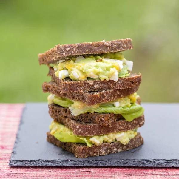 Sandwich mit Avocado und pochiertem Ei - gesundes Frühstückskonzept — Stockfoto