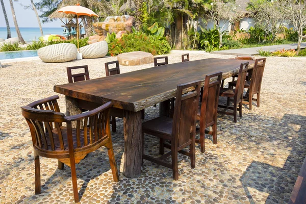 Tisch und Holzstühle im tropischen Strand neben dem Meerwasser, Thailand. Nahaufnahme — Stockfoto