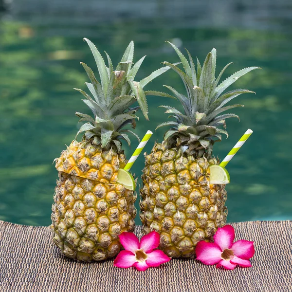 Pina colada cocktail in fresh two pineapples near swimming pool. Island Bali, Indonesia — Stock Photo, Image