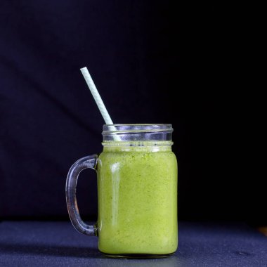 Avokado, muz, maydanoz ve siyah arka plan, üzerine bal dan taze yeşil smoothie yakın çekim