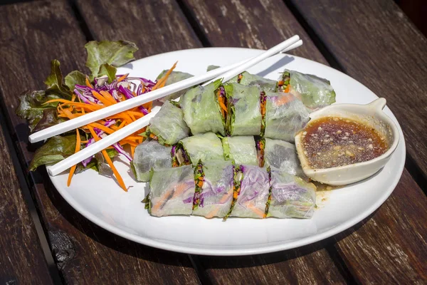 Свежие вьетнамские роллы на тарелке с салатом — стоковое фото