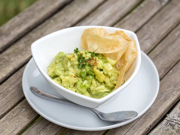 Guacamole di avocado con tortilla chips in una ciotola bianca , — Foto Stock