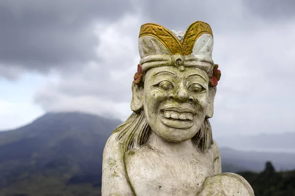 Traditional sculpture against background volcano Batur. Island Bali, Indonesia — Stock Photo, Image