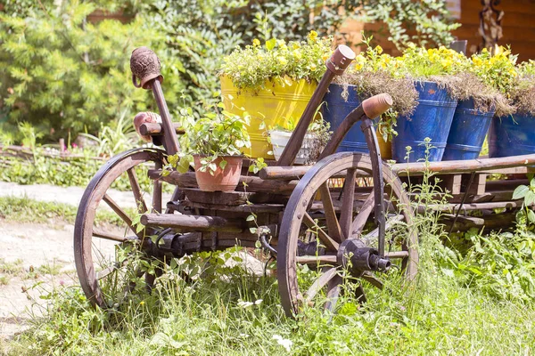 Vieille roue chariot en bois avec pots de fleurs dans le jardin. Montagnes des Carpates en été. Ukraine . — Photo