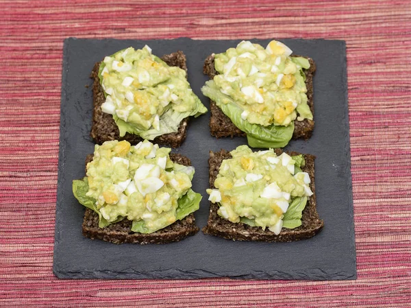 Sandwich con aguacate y huevo escalfado - concepto de desayuno saludable —  Fotos de Stock