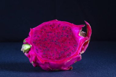Egzotik pembe dragonfruit siyah arka plan üzerine kesilmiş. Dragon meyve kapatın. Olgun kırmızı pitahaya meyve yarısı. Tatlı tropikal meyve