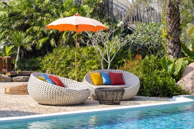 Tropikal plaj Yüzme havuzlu, hindistancevizi, rattan daybeds ve şemsiye deniz, Tayland yakınındaki palmiyeler
