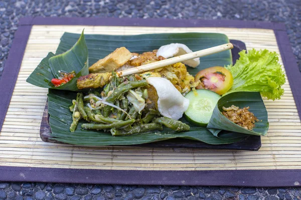 Nasi campur bali. Balinesisches Gericht aus gedämpftem Reis mit verschiedenen Beilagen. Nahaufnahme. asiatisches essen, ubud, bali, indonesien. Stockbild