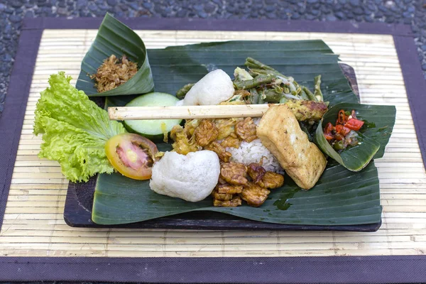 Nasi Campur Bali. Balinese schotel van gestoomde rijst met verschillende bijgerechten. Close-up. Aziatisch eten, Ubud, Bali, Indonesië. Stockfoto
