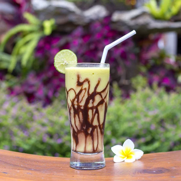 Batidos verdes orgánicos frescos de aguacate, plátano, cacao y miel en vidrio sobre mesa de madera. De cerca. — Foto de Stock