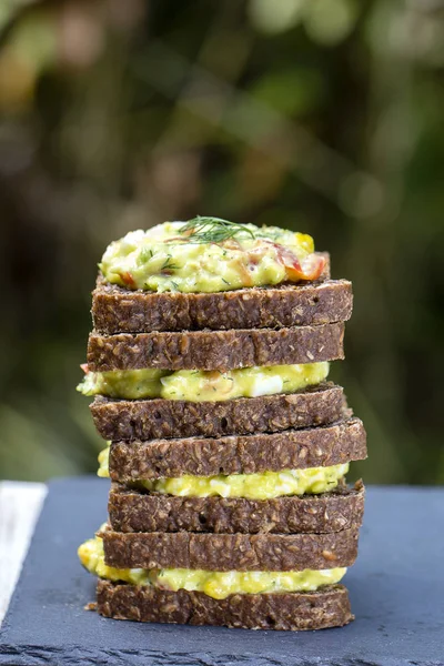 Sandwich con avocado, pomodoro, aneto e uova in camicia - concetto di colazione sana — Foto Stock